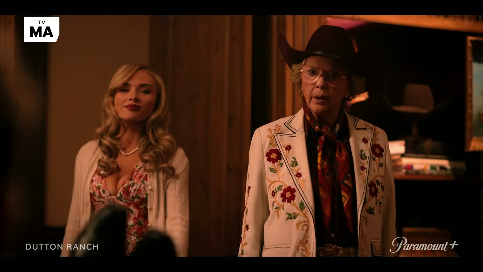 Beth Dutton walks through the crowded Ten Petal Ranch anniversary party as tensions rise between the Dutton and Jackson families in Dutton Ranch Season 1 on Paramount+