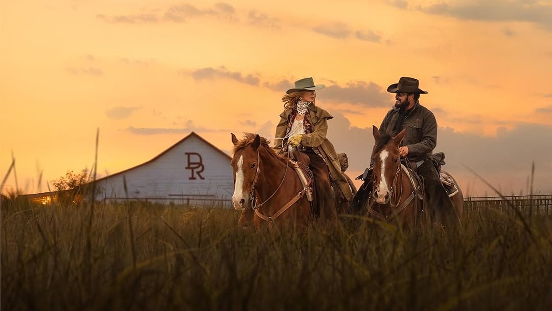 Beth and Rip Wheeler ride horseback at sunset in front of the Dutton Ranch barn in Rio Paloma, Texas